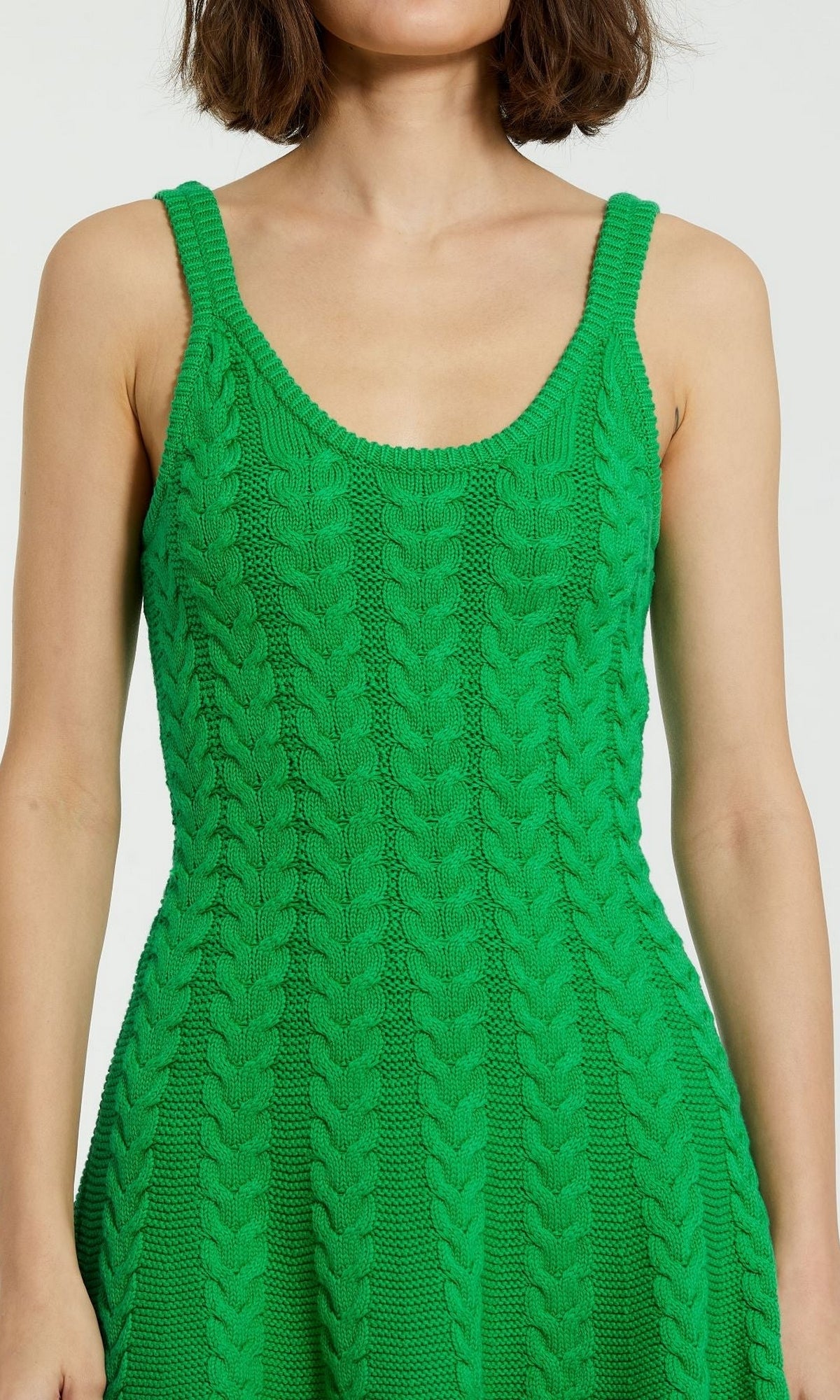 A person wearing a sleeveless, bright green Designer Short Knit Dress K12004 by Mac Duggal with a scoop neckline.